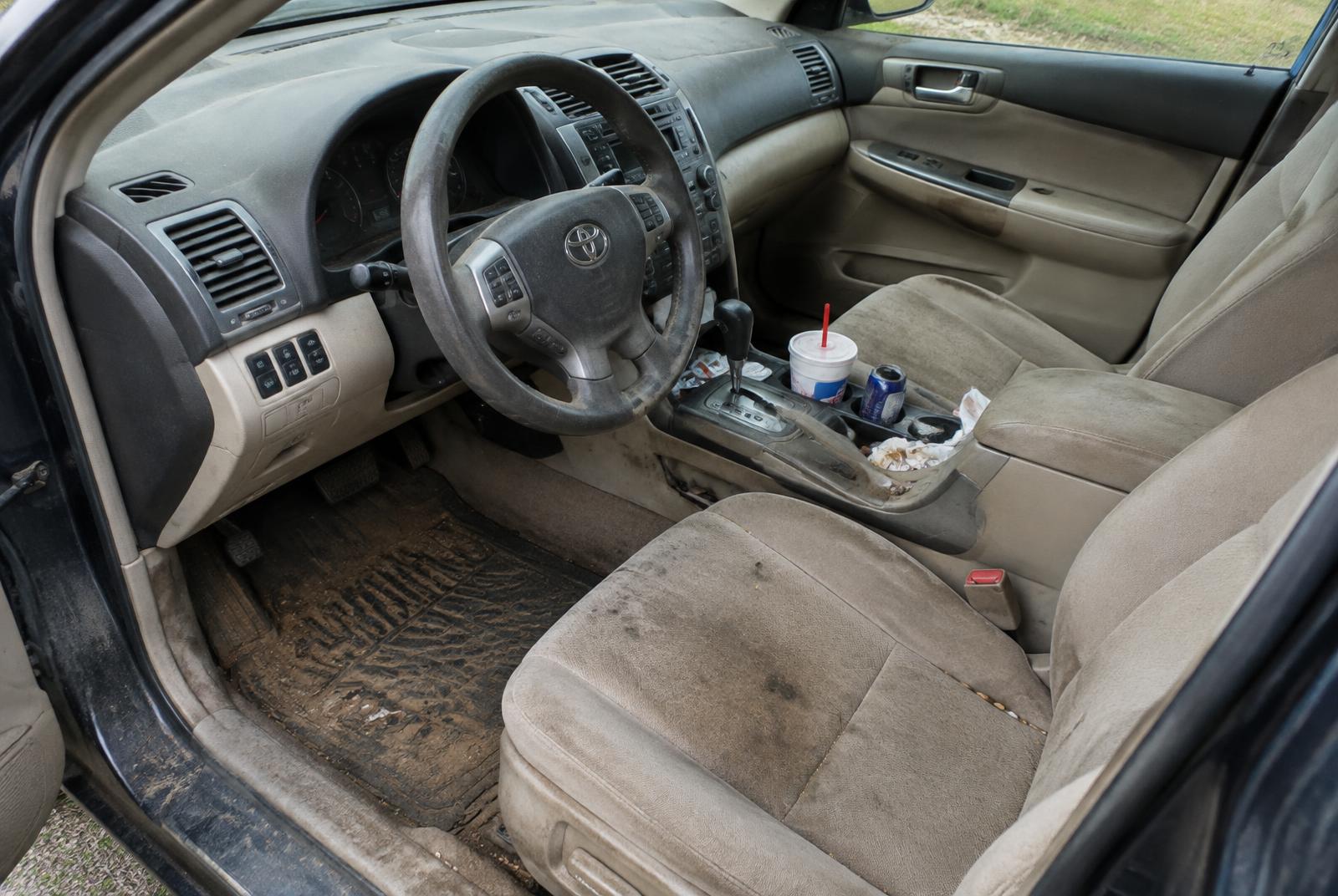 Dirty car interior with stained seats and muddy floor mats